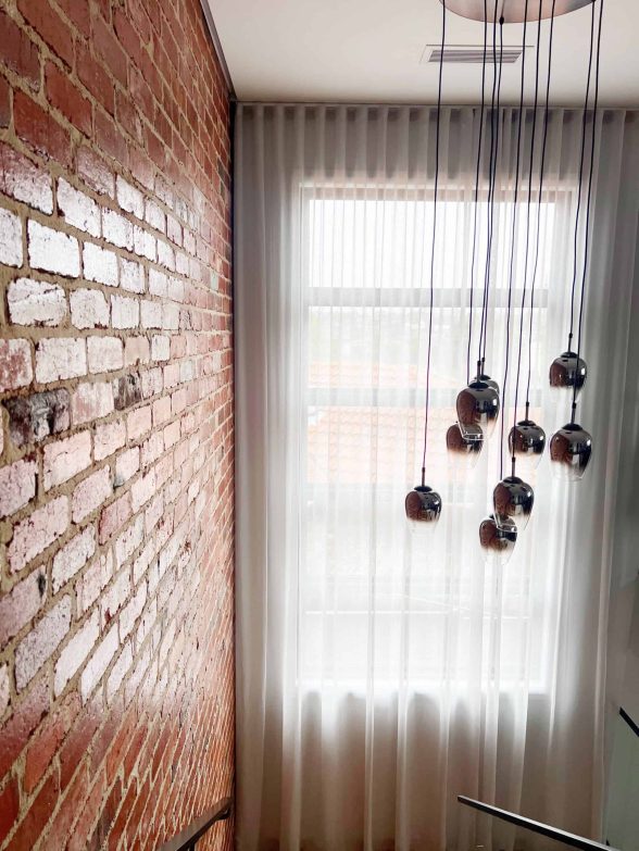 Bright sheer curtains with contemporary hanging light fixtures for a chic room look.